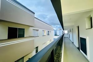 an empty corridor of a building with windows at Studio Citrino – Localização perfeita próx. da Ufu in Uberlândia