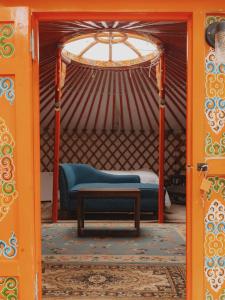an orange door with a blue couch in a yurt at Cosy yurt at a nature retreat in CA in Miramonte