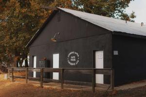 a black building with two white doors on it at Cosy yurt at a nature retreat in CA in Miramonte