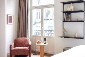 a living room with a chair and a window at Le Catherine by Sweett in Brussels