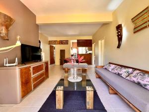 a living room with a couch and a tv at Bazaar Square Lodges in Grand-Baie