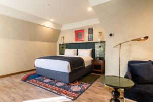 Un dormitorio con una cama, un sofá y una mesa. en Hotel Indigo Batumi - Old Town by IHG, en Batumi