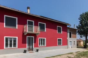 a red building with a balcony at Casa all'angolo in Rocchetta Tanaro