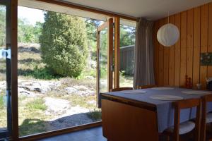 Private holiday home near the sea SE09157 في Spekeröd: مطبخ مع طاولة وباب زجاجي منزلق كبير