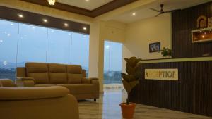 a living room with a couch and a chair at D D Luxury Inn in Chikmagalūr +77 photos
