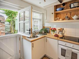 a kitchen with white cabinets and a sink and a window at 1 Bed in Tenterden oc-66342 in Tenterden