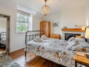 a bedroom with a bed and a fireplace and a mirror at 2 Bed in Mindrum oc-50973 in Crookham