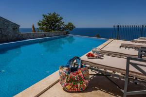 a purse sitting on a table next to a swimming pool at Olive Resort in Petrovac na Moru +40 photos
