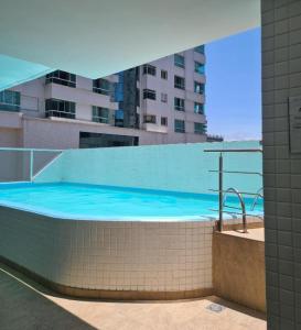 a swimming pool with blue water in a building at Apartamento espaçoso 2 quartos a 200 m da praia in Capão da Canoa