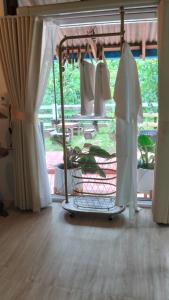 a clothes rack in a room with a window at Bansuan poordee บ้านสวนพอดี in Hat Yai