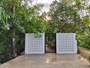 a gate in a garden with trees in the background at Bansuan poordee บ้านสวนพอดี in Hat Yai