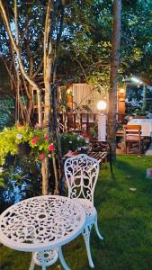 a white table and chair sitting in a yard at Bansuan poordee บ้านสวนพอดี in Hat Yai