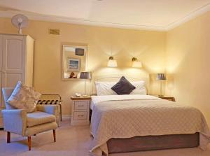 a bedroom with a bed and a chair and lamps at Waterloo Lodge in Dublin
