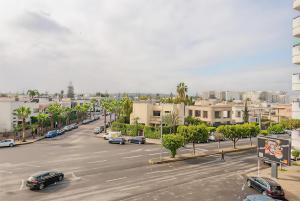 een stadsstraat met auto's geparkeerd op een parkeerplaats bij Luxury Central 3BR 5min from Beach & Shopping in Casablanca