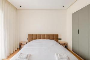 een bed in een kamer met witte muren en gordijnen bij Luxury Central 3BR 5min from Beach & Shopping in Casablanca
