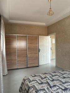 a bedroom with a bed and a white door at Ber appartement in Mirleft +12 photos