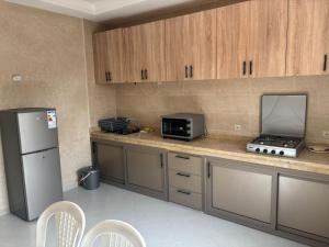a kitchen with a counter with a refrigerator and a microwave at Ber appartement in Mirleft