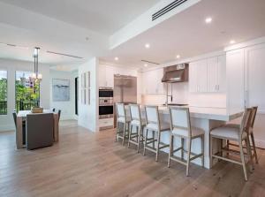 a kitchen with white cabinets and a table and chairs at Stylish Downtown Naples Retreat in Naples