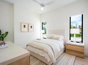 a white bedroom with a bed and a window at Stylish Downtown Naples Retreat in Naples +9 photos