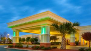a building with a palm tree in front of it at Holiday Inn Lumberton by IHG in Lumberton