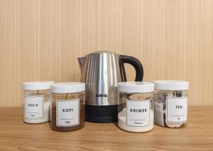 a group of five jars and a kettle on a table at Trevista With Private Pool in Curug 1