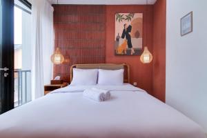 a bedroom with a bed with white sheets at Trevista With Private Pool in Curug 1 +19 photos