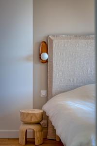 villa California - Villa d'exception avec vue mer panoramique - Veules-les-Roses في فول-لي-روز: غرفة نوم مع سرير مع كرسي خشبي بجانبها