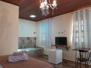 a bedroom with a bed and a television and a table at Recanto dos Açores in Florianópolis