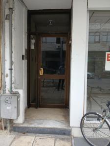 Κεντρικο ΔΙΑΜΕΡΙΣΜΑ ΣΤΑ ΤΡΙΚΑΛΑ في تريكالا: باب مفتوح لمبنى مع دراجة مركونة في الخارج