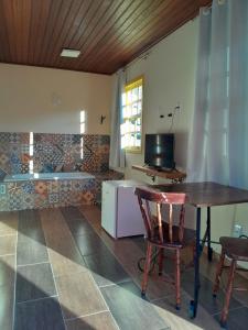 a living room with a table and chairs and a tub at Recanto dos Açores in Florianópolis