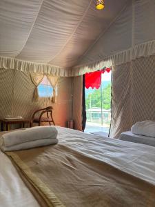 Cama blanca grande en habitación con mesa en Baromas Resort and Camping, en Kailāna