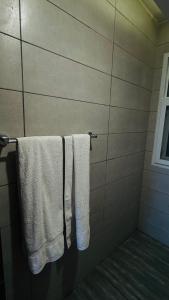 uma casa de banho com toalhas brancas penduradas numa parede em Gold Crest Lahore - Guest Nest Luxury Stays em Lahore