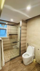 um banheiro com vaso sanitário e box de vidro em Gold Crest Lahore - Guest Nest Luxury Stays em Lahore