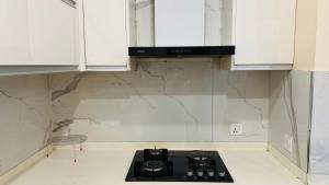 uma cozinha com armários brancos e um fogão com forno em Gold Crest Lahore - Guest Nest Luxury Stays em Lahore