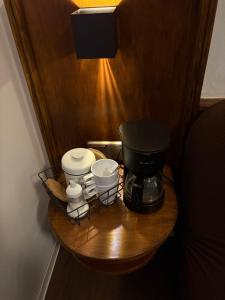 a coffee maker and cups on a wooden table at Junges Wohnen zwei in Weikersheim