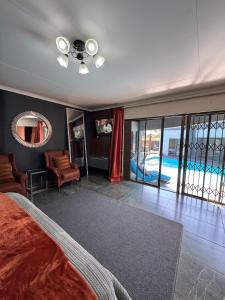 a bedroom with a bed and a swimming pool at Zee Lifestyle Guesthouse in Vanderbijlpark +6 photos