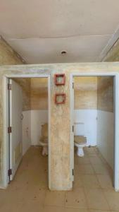 an empty bathroom with two toilets in a room at OYO 75597 The Tewsone Resort in Sukhothai