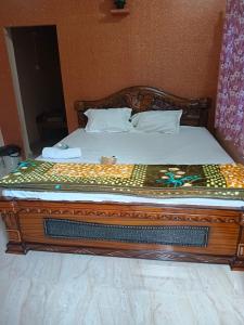 a bed in a room with a wooden frame at Manvitha Homestay in New Hampi