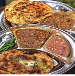 un piatto di alimenti con diversi tipi di alimenti su cui è presente; di Radhika P Guest House Ajmer welcome to all family friends groups fully airconditioner attach washroom with geeser near by railway station near by Bus stand less than 1 km a Ajmer