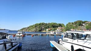 Stay central & close to the sea in Henån SE09155 في Näset: مجموعة من القوارب مرساة على رصيف في الماء