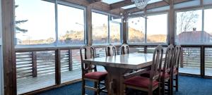 Stay central & close to the sea in Henån SE09155 في Näset: غرفة طعام بها طاولة وكراسي ونوافذ