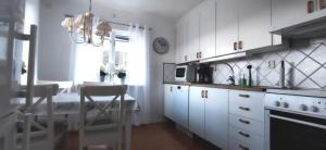 Stay central & close to the sea in Henån SE09155 في Näset: مطبخ مع دواليب بيضاء وطاولة طعام +17 صورة