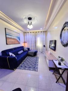 a living room with a blue couch and a table at Studio idéal pour vos sejours in Dakar