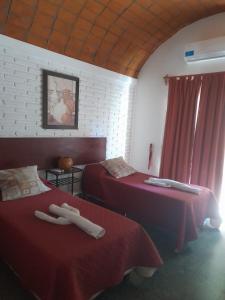2 camas en una habitación con sábanas rojas en Toneles - Cafayate, en Cafayate