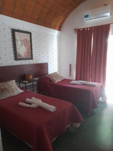 Una habitación de hotel con dos camas con sábanas rojas. en Toneles - Cafayate, en Cafayate 9 fotos más