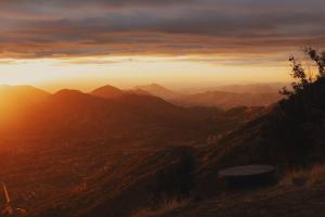 a view of a mountain range with the sun setting at Glamping yurt at Sequoia Highland Camp in Miramonte