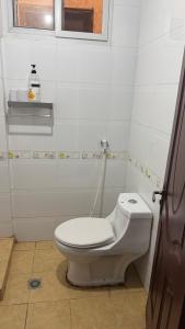 Masaki H and Apartment في دار السلام: حمام مع مرحاض أبيض ونافذة