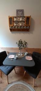 a table with a vase on it with two chairs at Haus Porsche in Hellenthal