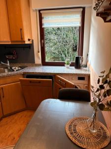 a kitchen with a table with a vase on it at Haus Porsche in Hellenthal