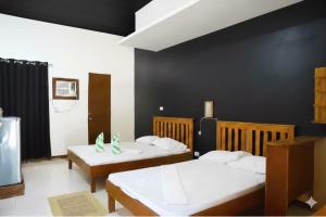 una camera con due letti e una parete nera di D Mountain Beach Resort a Puerto Galera
